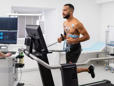 Athlete does a cardiac stress test in a medical study, monitored by the female doctor.