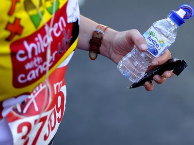 A runner holds an energy bar and a bottle of water during the Virgin Money London Marathon on April 13, 2014 in London, England.
