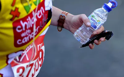 A runner holds an energy bar and a bottle of water during the Virgin Money London Marathon on April 13, 2014 in London, England.