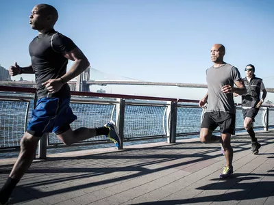 Runners running along a river