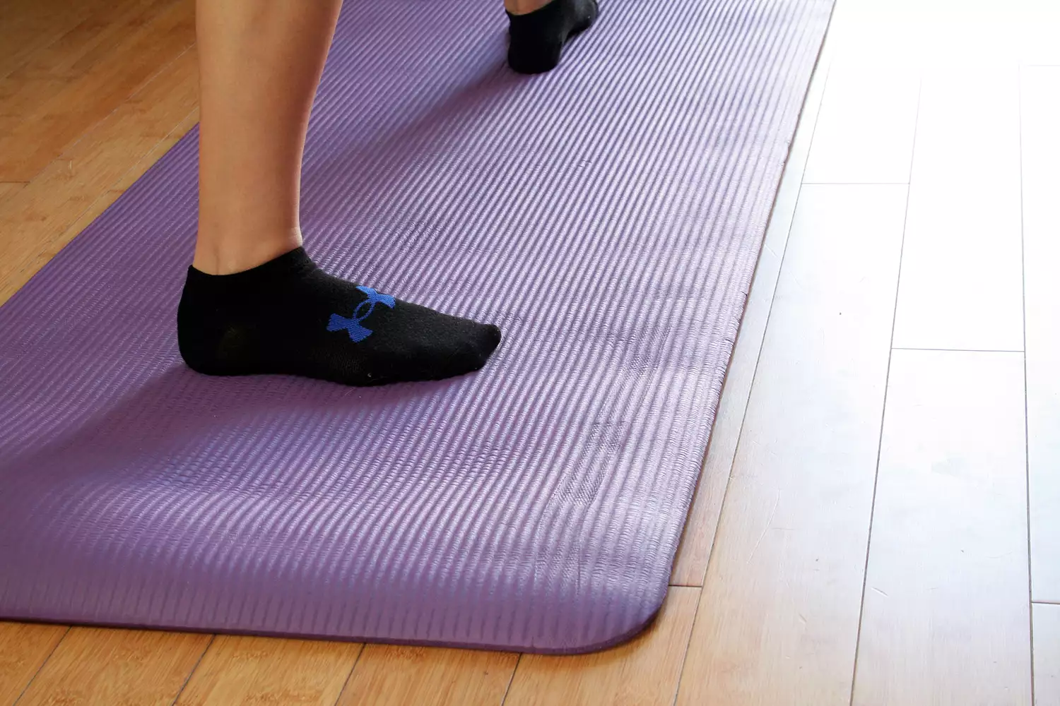 Person standing on BalanceFrom GoYoga All-Purpose Yoga Mat while performing yoga