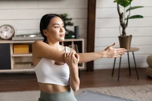 Young woman stretching during cool down after exercising. 