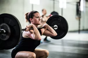 Woman lifting barbell at a gym