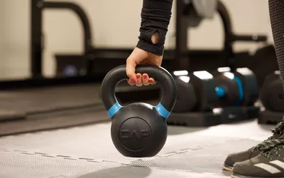 Person picking up a CAP Barbell Cast Iron Competition Kettlebell Weight