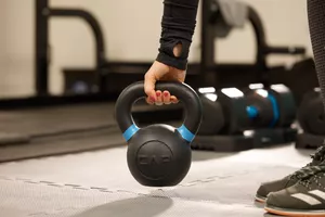 Person picking up a CAP Barbell Cast Iron Competition Kettlebell Weight