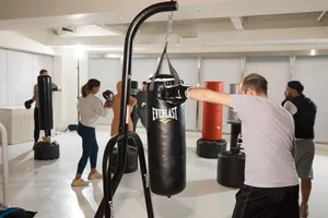 People punching several top punching bags
