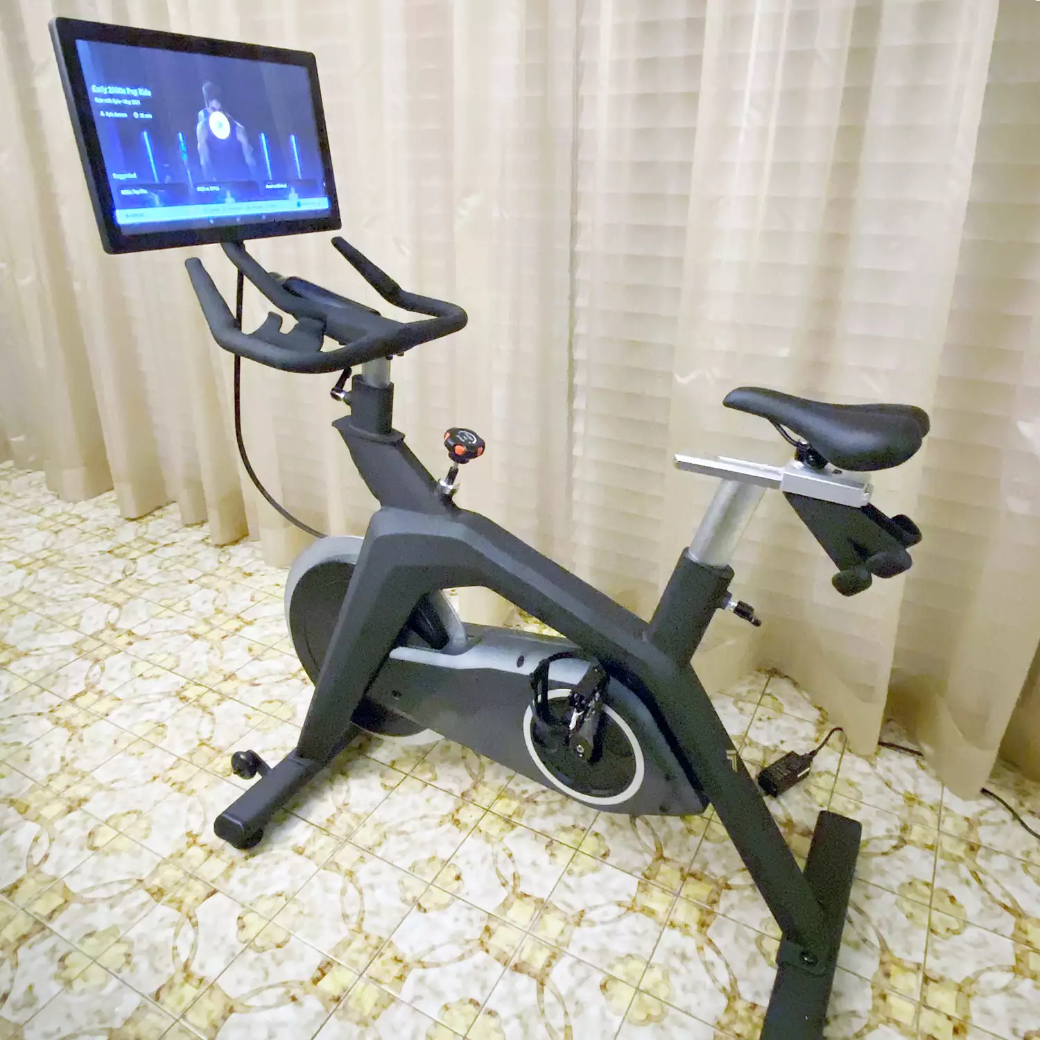 Stryde The Bike set up on tile floor next to a window with curtains