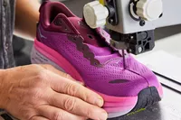 Hoka Women's Bondi 8 sneaker being cut in half with a band saw 