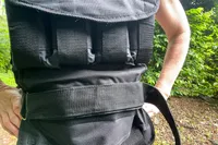 A person wears the CAP Barbell 20-150 Lb Adjustable Weighted Vest with the strap around their waist