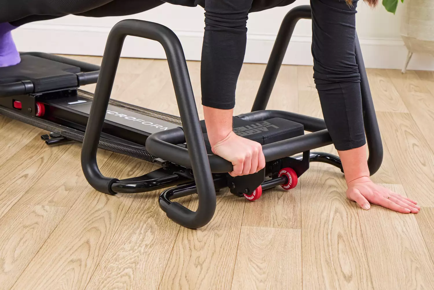 A person exercises using the Lagree Micro Reformer