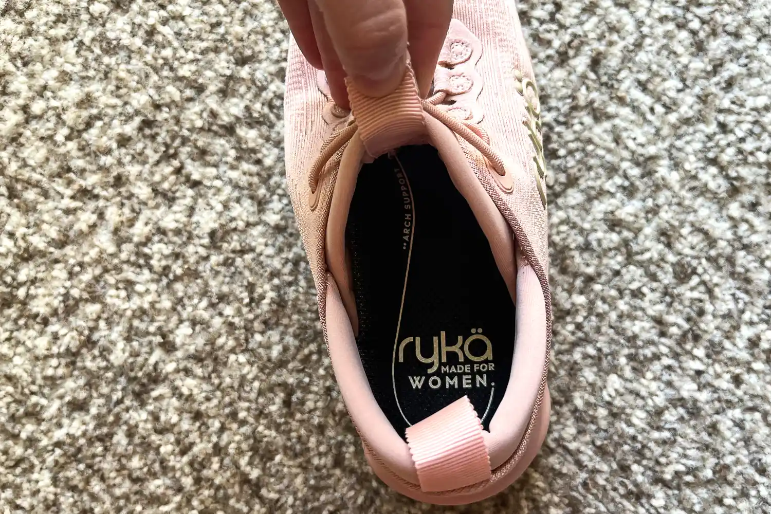 A person holds the tongue on the Rykä Women's Podflow EZ Walking Sneaker open