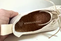 The brand name on the insole of the Vivobarefoot Women's Primus Lite Knit Natural Sneaker