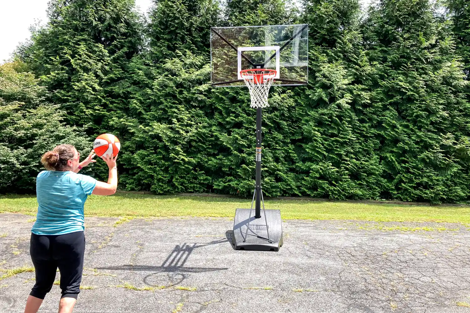 A person shoots the Wilson WNBA Authentic Outdoor Basketball