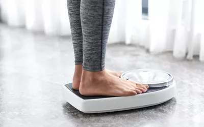 Young healthy girl on home scales