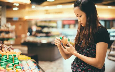 Young lady look at nutrition labels in supermarket