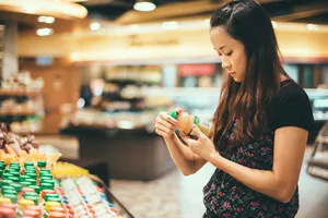 Young lady look at nutrition labels in supermarket